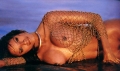 Traci Bingham laying topless in the water
