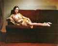 Christina Ricci in glamorous dress is sitting on stylish couch