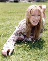 Hilary Duff smiling while laying on the grass