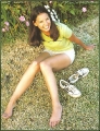 Katie Holmes posing on the grass showing her awesome legs
