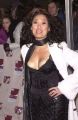 Tia Carrere wearing black dress with plunging neckline