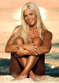 Torrie Wilson sitting nude on the beach